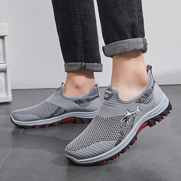 Man wearing the men's slip on walking shoes in Gray