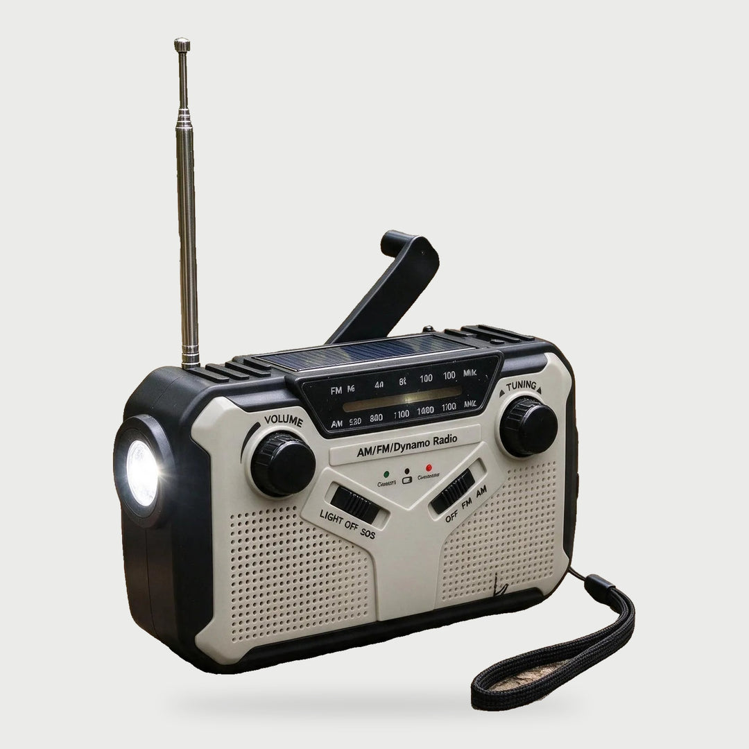 Gray wind up radio with AM FM dial, hand crank and wrist strap