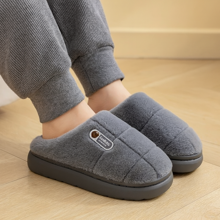 Wearing gray fuzzy platform slippers at home