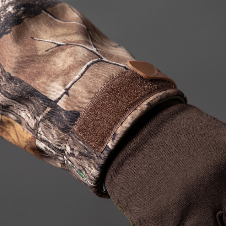 Hook-and-loop velcro cuff tab on men's camo hunting jacket pulled over a gloved wrist