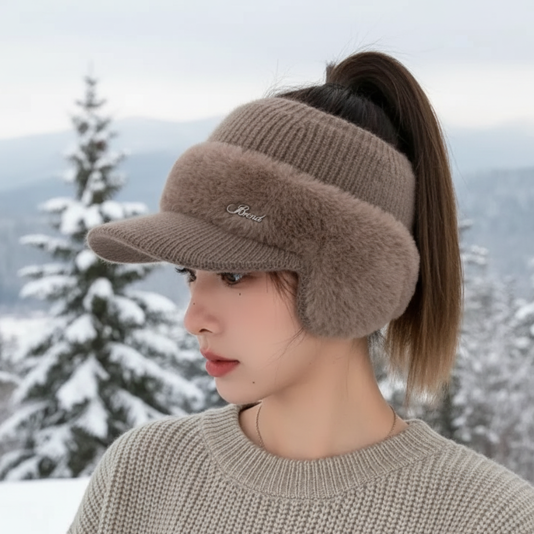 Woman wearing the khaki ponytail beanie with plush ear warmers in the snow