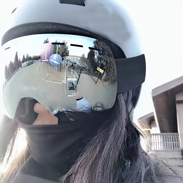 Woman wearing the mirrored ski goggles over a helmet