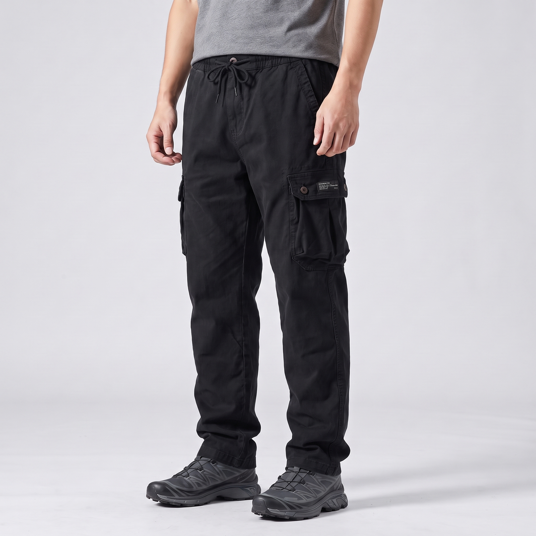 Three-quarter side view of black cargo pants with the drawcord tied, showing the two-button thigh cargo pocket and straight leg