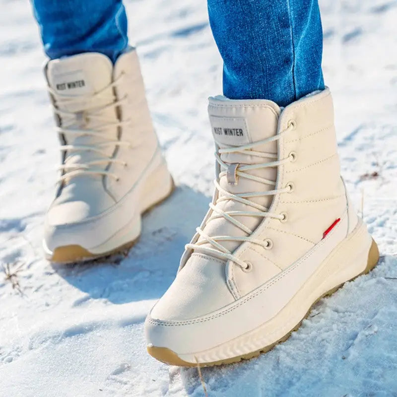 Woman walking in snow in the Beige quilted lace up winter boots