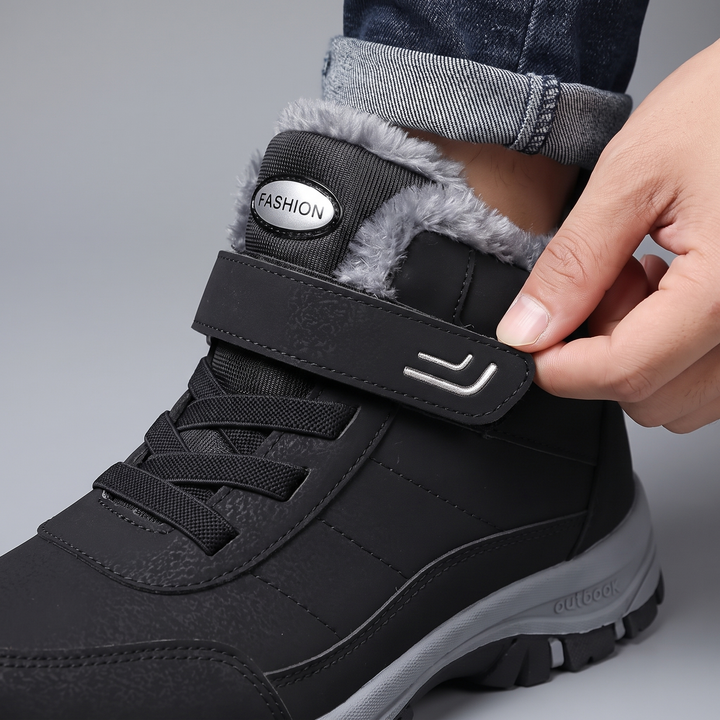 Hand closing the hook-and-loop strap over the laces of a winter boot