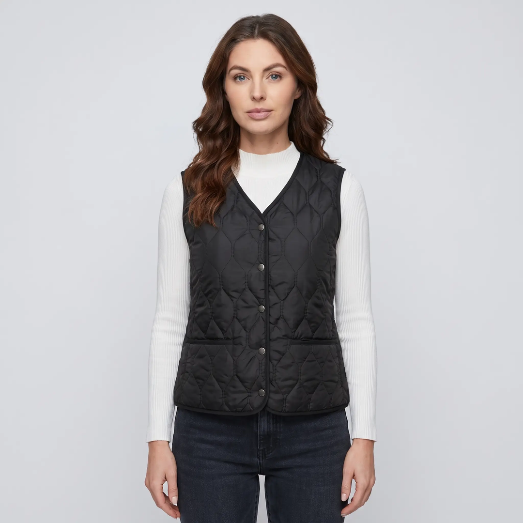Woman wearing the Black quilted puffer vest with snap front over a ribbed top