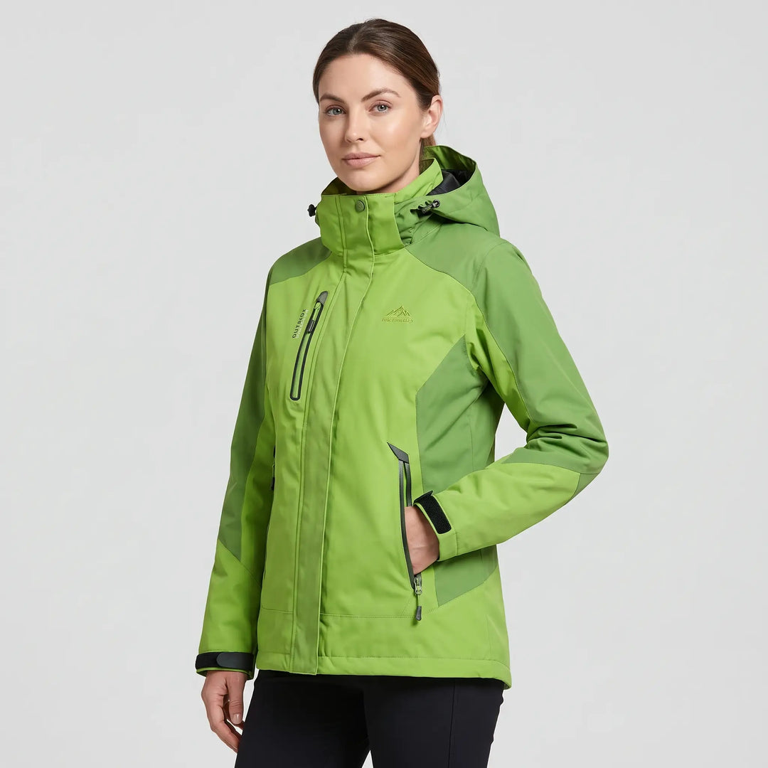 Green insulated rain jacket on a woman, three-quarter view showing the stand collar and two-tone panels
