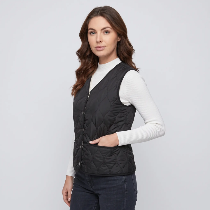 Women's quilted puffer vest in Black, three-quarter view with welt pocket