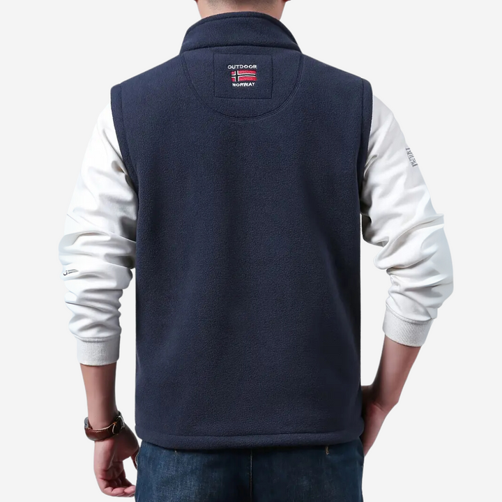 Back of the navy fleece vest showing the plain panel and collar patch
