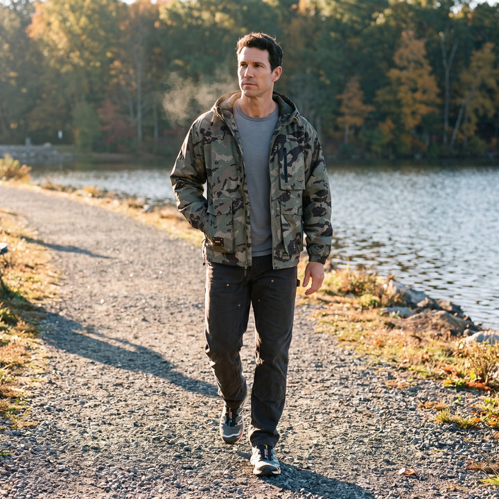 Man wearing the khaki camo hooded jacket on a lakeshore trail