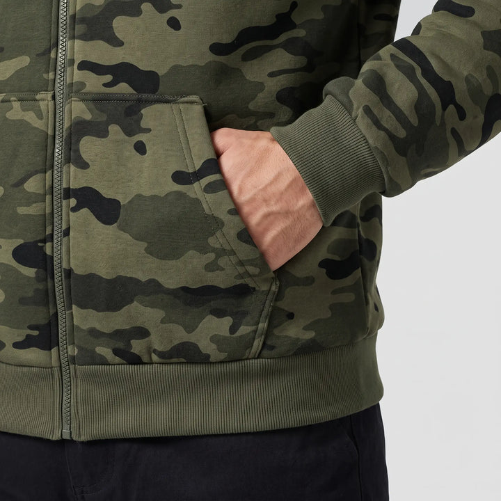 Hand in the front pocket of the camo hoodie with rib cuff and hem