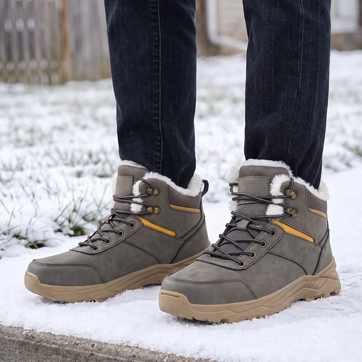 Gray boots worn on a snowy sidewalk