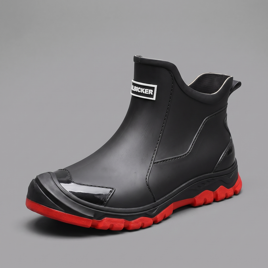 Black PVC slip-on ankle rain boot with a red outsole