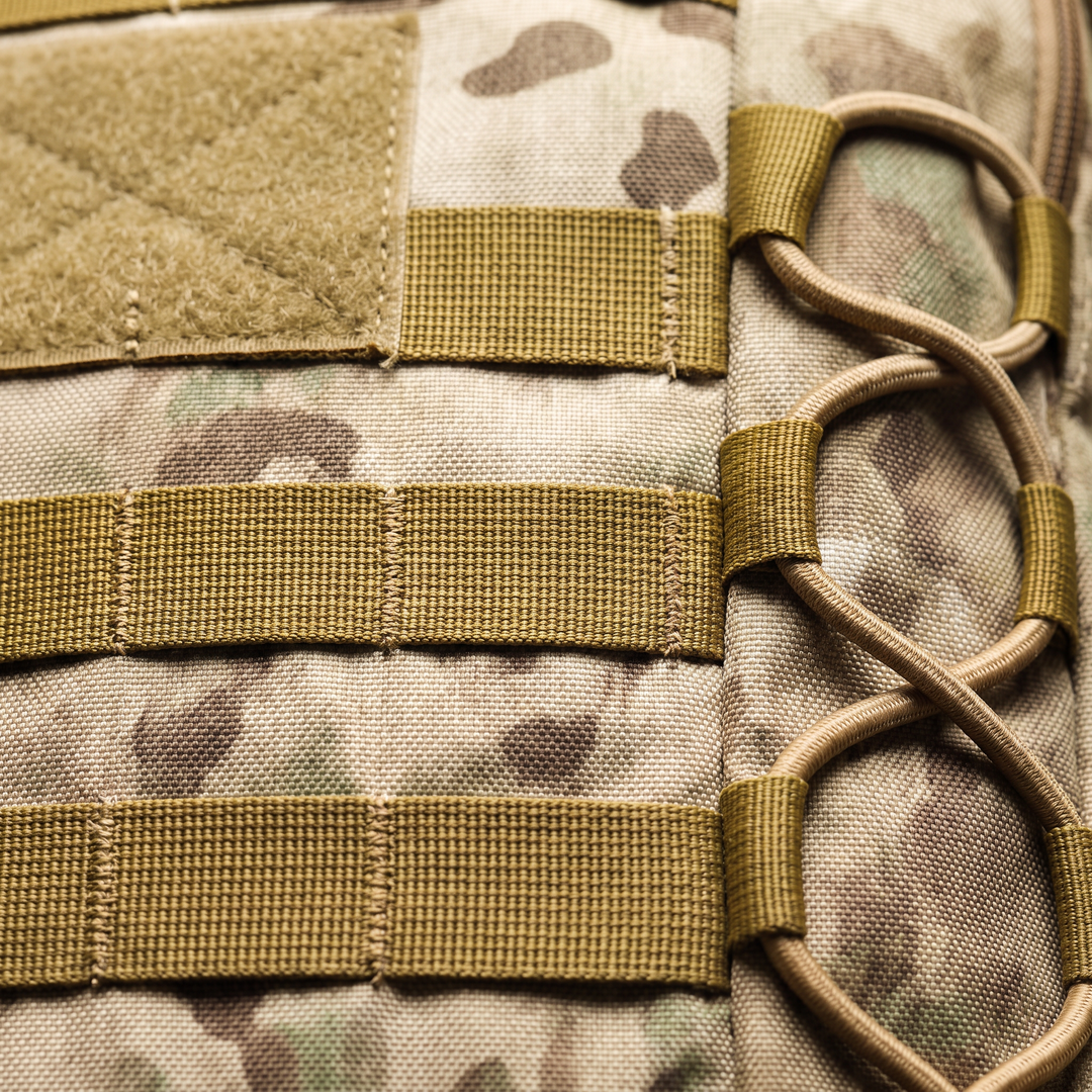 Close-up of the MOLLE webbing rows and the bungee flank lacing