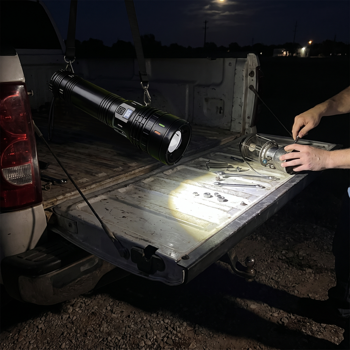 Flashlight hung from its shoulder sling lighting a truck tailgate